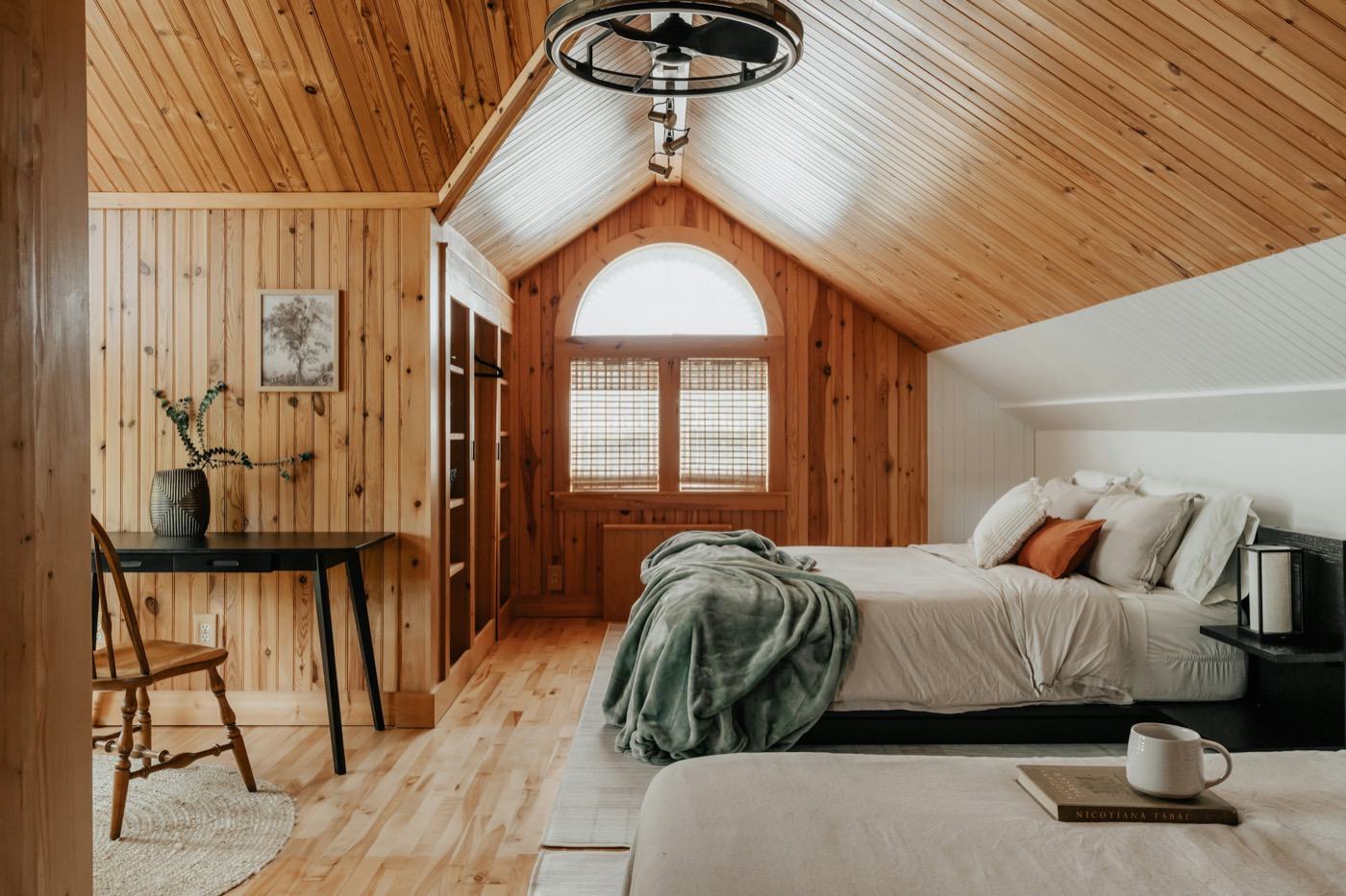 Pine Room under a vaulted pine ceiling with white linen and an arched window